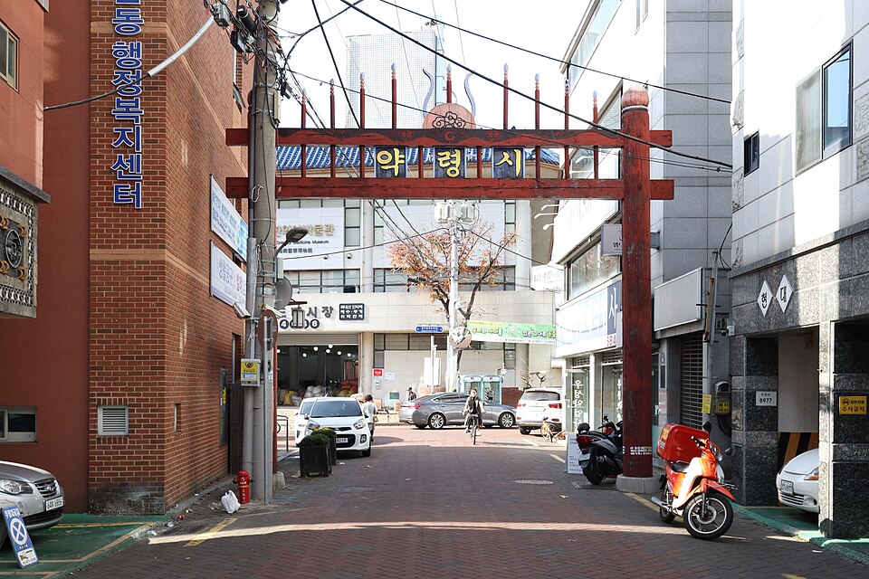 대구 약령시 표지가 걸린 붉은 아치와 골목 입구